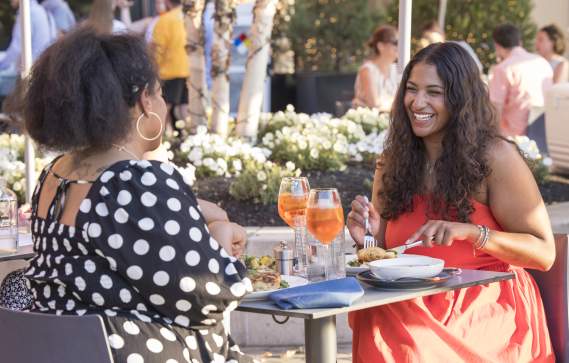 Two Black women having dinner at Alcove restaurant al fresco