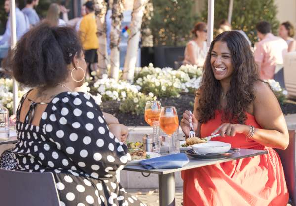 Two Black women having dinner at Alcove restaurant al fresco