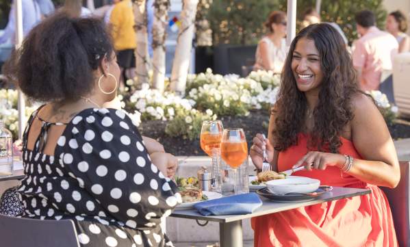 Two Black women having dinner at Alcove restaurant al fresco