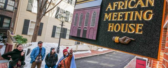 4 people looking at a sign that reads "Museum of African American History; African Meeting House."