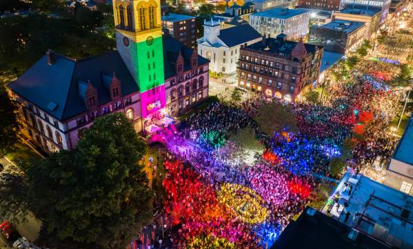 Aerial view at night of the Cambridge Dance Party, building and crowd illuminated by colorful lights