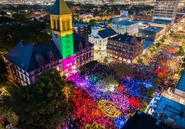 Aerial view at night of the Cambridge Dance Party, building and crowd illuminated by colorful lights