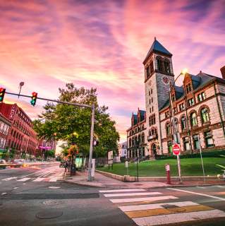 Stylized image of Cambridge buildings with purple sunset behind them