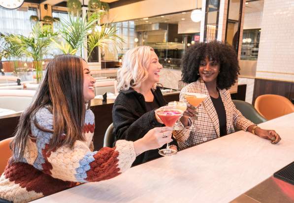 Three friends grabbing drinks during Dine Out Boston