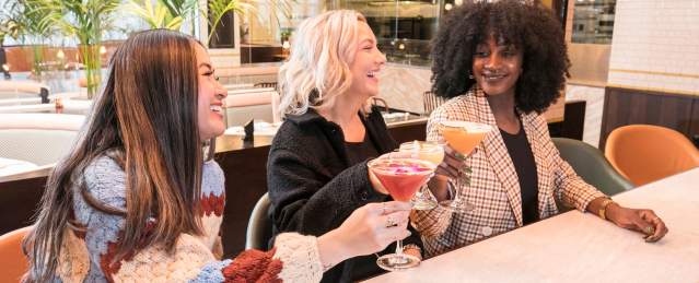 Three friends grabbing drinks during Dine Out Boston