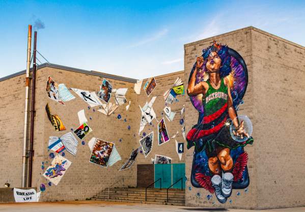 Mural depicting child wearing a dress reading Roxbury blowing bubbles and surrounded by blowing posters and books