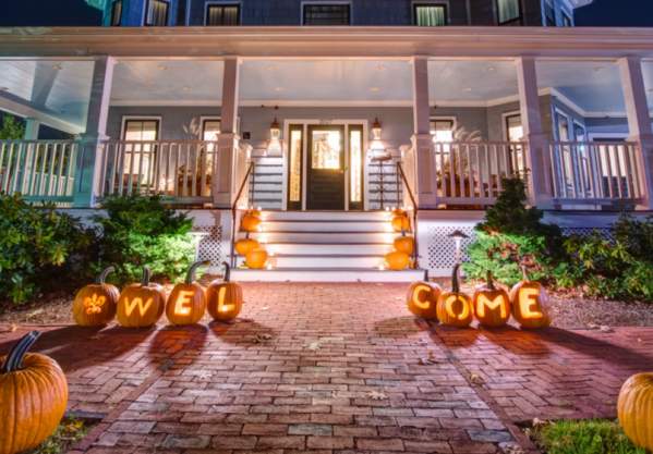 The Inn at Hastings decorated with pumpkins lit up along the front walkway.