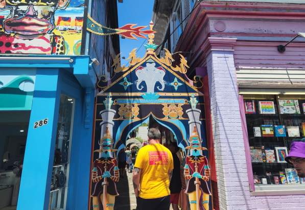 guy walking through colorful alley