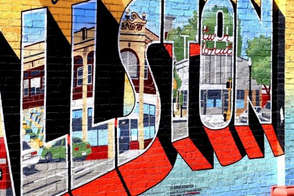 Mural of a postcard reading Greetings from Allston Village